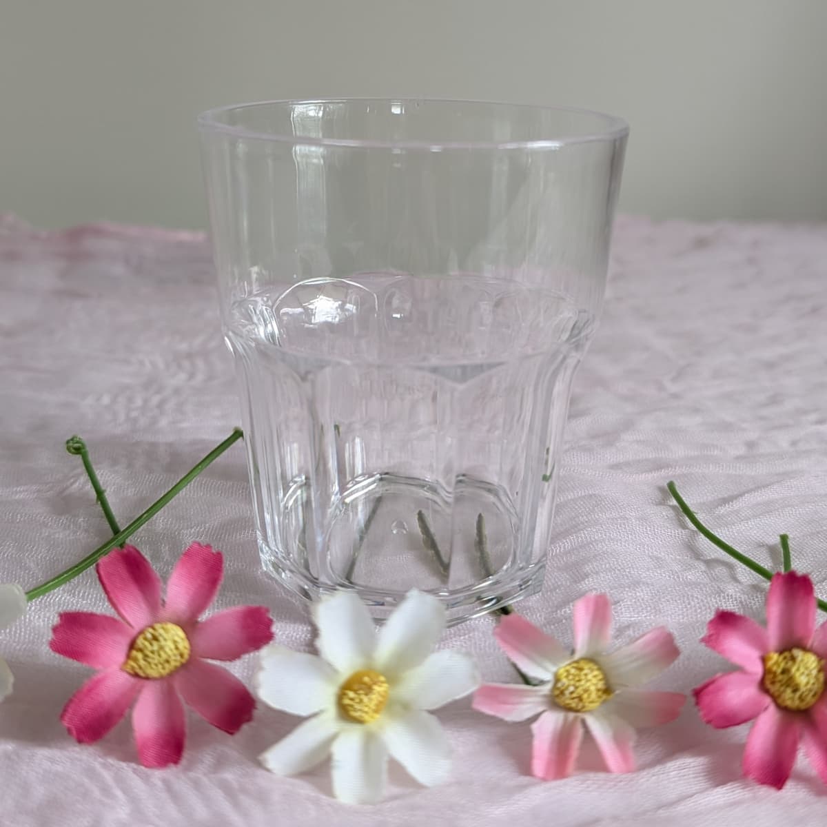 Single small acrylic tumbler close-up with daisies