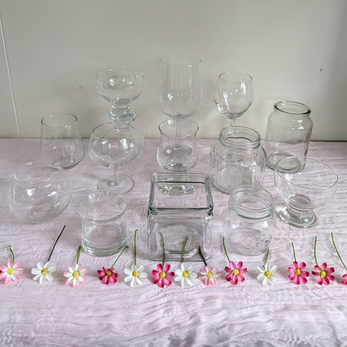 Assorted clear glass jars and vessels for lolly buffet with daisies