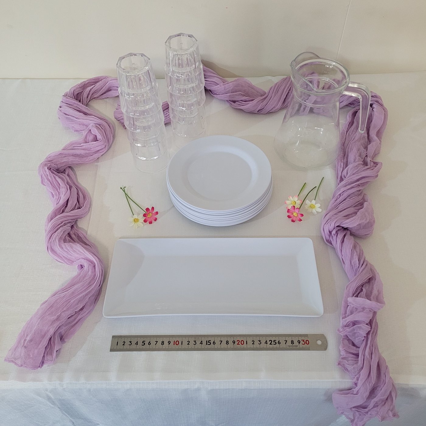 Starter setup with lilac cheesecloth runner, plates, tumblers and platter